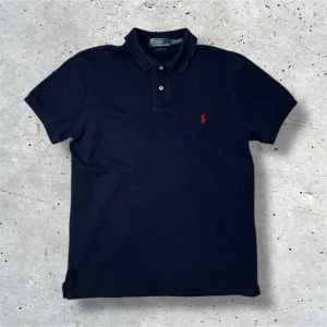 Ralph Lauren piké marinblå - Marinblå piké från Ralph Lauren i stl M. Tröjan är i väldigt bra skick utan några slitage. Hör av er vid frågor, pris kan diskuteras vid snabb affär!