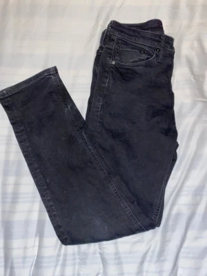 Svarta jeans från Jack & Jones Regular Clark - Svarta jeans från Jack & Jones, modell Regular Clark. Klassisk femficksdesign med raka ben och normal passform. Jeansen är tillverkade i slitstarkt bomullsmaterial och har diskreta sömmar och knapp med logotyp. Perfekt för dig som gillar enkel och stilren look. Säljs för 150 | Nypris - 900kr 