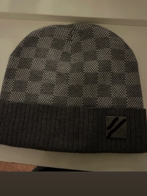 Grå rutig mössa med ribbad kant - Snygg grå mössa med rutigt mönster och bred ribbad kant. Hör gärna av er för mer bilder och detaljer. Pris kan diskuteras.