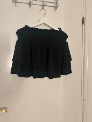 Svart volangkjol från SHEIN XS - Säljer en svart kortkjol från SHEIN i storlek XS. Kjolen har två lager med volanger och ett smockat midjeparti som ger en snygg och bekväm passform. Perfekt för dig som gillar en feminin och trendig stil. Utstrechad på bilden!!💗