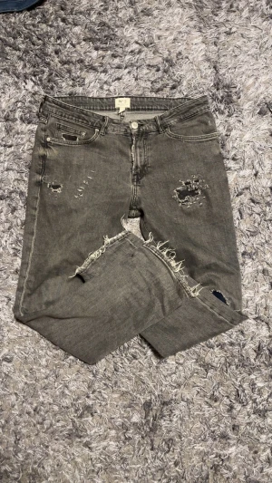 Grå slitna jeans  - Grå jeans med regular fit, modell N°2. Byxorna har slitna detaljer, lagade hål och patchar.