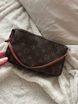 Louis Vuitton brun handväska med monogram - Säljer en klassisk brun handväska från Louis Vuitton med ikoniskt monogrammönster i guldton.                          I väldigt fint skick, helt luktfri!!   Dragkedjan har något slitage men funkar perfekt!   Alla bevis på äkthet finns , kan skickas vid förfrågan.