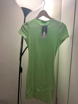 Ljusgrön ribbad kortklänning FB Sister - Superfräsch ljusgrön kortklänning från FB Sister med ribbad struktur och rund hals. Klänningen har korta ärmar och en tight passform som framhäver figuren. Perfekt för dig som gillar en enkel men snygg stil.