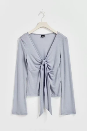 Ljusblå omlottopp från Gina Tricot - Trendig ljusblå omlottopp från Gina Tricot med lång ärm och djup v-ringning. Toppen har knyt framtill som ger en snygg och croppad look. Perfekt att styla med jeans eller kjol för en cool outfit.