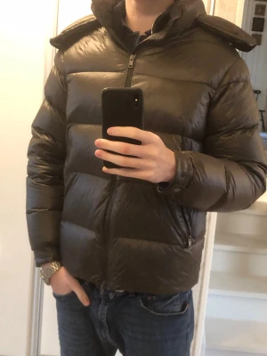 Massimo Dutti Pufferjacka - Tja, säljer en olivgrön pufferjacka från Massimo Dutti. Absolut inga problem eller defekter på jackan. Nypris ligger på 2500, mitt pris:999. Killen på bilden är 185cm och ungefär 70kilo. Tveka inta att höra av dig kring eventuella frågor. Pris är ej hugget i sten