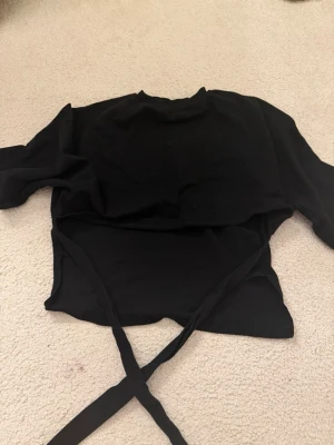 Svart tröja med öppen rygg - Öppen rygg tröja från Nelly, knyt. Jätte fin
