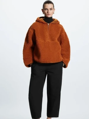 Rustbrun teddyjacka med huva - Mysig oversized teddyjacka i teracottafärg med huva och half zip-dragkedja framtill. Jackan har stora ärmar och en avslappnad passform, perfekt för lager-på-lager. Tillverkad i fluffigt teddy-material i ullmix som håller dig varm. Ny utan prislapp, inga anmärkningar. 