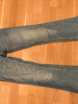 Blå jeans från weekday - Säljer ett par jeans från weekday i modellen booty bei. Färgen är som den var i ny skick då jeansen intense använda så många gånger. Byxorna är low waist och utsvängda där nere. Medela om storlek!