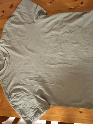 Ljusgrå basic t-shirt från Weekday - Enkel och stilren ljusgrå t-shirt från Weekday. Klassisk rund halsringning och korta ärmar. Tillverkad i mjuk bomull som känns skön mot huden. Perfekt att matcha med jeans eller shorts för en clean look.