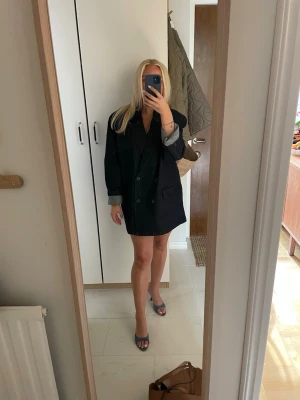 Oversized svart kavaj - Snygg oversized svart kavaj med klassisk krage och knappar framtill. Kavajen har långa ärmar och två stora fickor framtill. Perfekt att styla till olika looks för en trendig vibe. Nypris 899kr