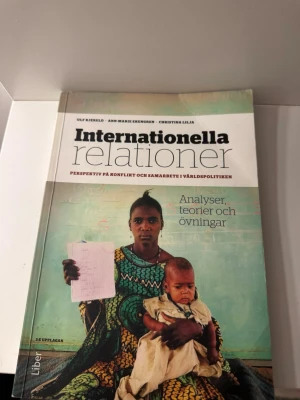 Internationella relationer bok - Kursbok med titeln 'Internationella relationer', skriven av Ulf Bjereld, Ann-Marie Ekengren och Christina Lilja. Omslaget har en bild på en person med barn och texten 'Analyser, teorier och övningar'. 3:e upplagan.