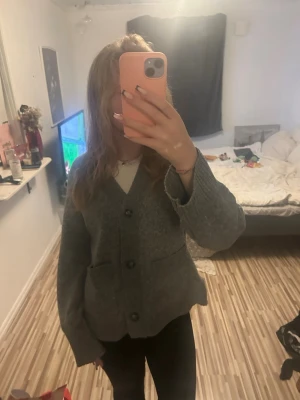 Grå fitted kofta/cardigan med fickor - Mysig grå kofta/cardigan knappar framtill och två rymliga fickor. Koftan har lång ärm och är stickad i ett mjukt material, perfekt för lager på lager. Enkel och stilren design som passar till det mesta. Ifrån lagar 157 i storlek Xs. Nypris-200 Säljer för-100, då den är använd få gånger🥰 skriv vid frågor eller prisförslag!!:))