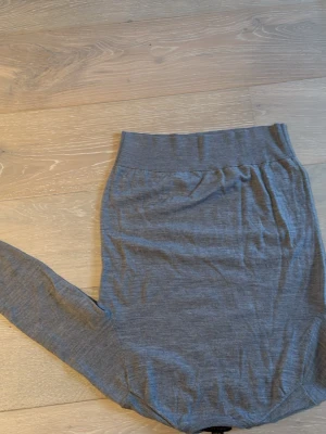 Grå stickad tröja från Polo Ralph Lauren - Klassisk grå stickad tröja från Polo Ralph Lauren i tunt, mjukt material. Tröjan har rund halsringning, långa ärmar och ribbade muddar vid ärmslut och nederkant. Perfekt för lager på lager och enkel att matcha med olika stilar.