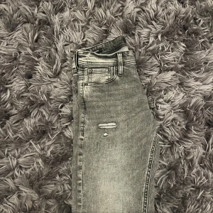 Jack & Jones Jeans Slim Glenn - Snygga grå jeans från Jack & Jones med slitna detaljer och slim fit. Jeansen har klassisk femficksdesign, dragkedjegylf och är tillverkade i  denim för en perfekt passform. Perfekta för dig som gillar en trendig och grisch look.