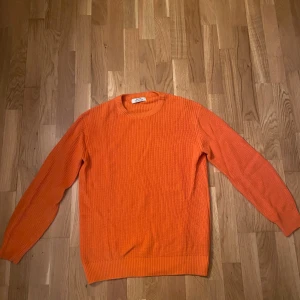 Orange stickad tröja från Bershka - Säljer en orange stickad tröja från Bershka i storlek S. Tröjan har rund halsringning, ribbade muddar och är långärmad. Varm och skön till vintern! Nypris 400kr