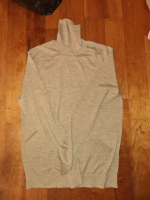 Beige polotröja - Snygg beige polotröja från Selected Homme i mjuk merinoull och coolmax-material. Tröjan har lång ärm, ribbade muddar och en hög krage som ger en clean och stilren look. Perfekt för dig som gillar minimalistisk stil och vill ha något som är både bekvämt och trendigt. Perfekt nu för det kyliga vädret, hör gärna av er vid funderingar eller prisförslag🙌🏼