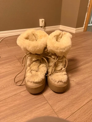 Beigea fluffiga vinterskor  - Supersöt fluffiga vinterskor som endast är använda två gånger förra året. Skon är i mycket bra skick!💕 jag har 39 i skostorlek med det fungerar eftersom man själv knyter runt foten!