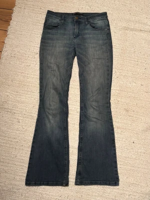 Mörkblå bootcut jeans - Snygga mörkblå jeans med bootcut passform och klassisk femficksdesign. Jeansen har en lätt tvättad look och är tillverkade i mjukt denimtyg. Nypris ca 2000. 