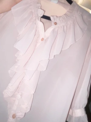 Ljus rosa bluse - Ljus råsa, ser mer rosa ut i verkligheten. Ifrån saint tropez, storlek vet jag inte men M antar jag. Den är rufflig och väldigt elegant 