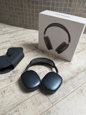 Apple AirPods Max Svart Over-ear - Snygga svarta Apple AirPods Max over-ear hörlurar med stilren design. Tillverkade i aluminium och rostfritt stål med mesh-båge för extra komfort. Kommer med smart skyddsfodral och originalförpackning. Perfekta för musik, gaming eller film.