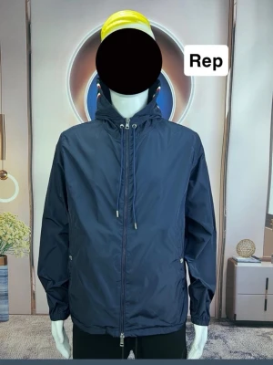 Moncler liknande jacka  - Stilren mörkblå vindjacka med huva och dragsko. Jackan har dragkedja framtill, två sidofickor med dragkedja och elastiska muddar vid ärmslut. Perfekt för blåsiga dagar och enkel att matcha med olika outfits. 