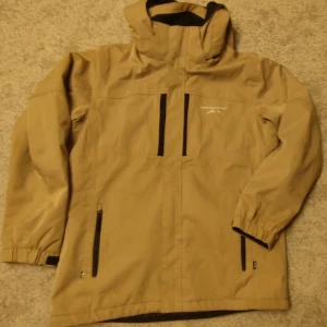 Skidjacka  - Fin herr skidjacka från Swedmount. I bra skick.En kardborre i snölåset fram är trasig i sömmen, men inget som stör funktionen. Storlek M herr. 