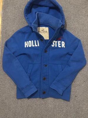 Vintage Cardigan Med Knappar - Säljer denna feta hollister cardigan med knappar | Bra skick, synliga tecken på använding finns, se bilder därav billigt pris! | Längd ≈ 61cm Bredd armhåla - armhåla ≈ 50cm | 