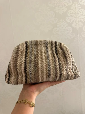 Clutch bag - Super fin clutch bag som inte kommer till användning, vet ej märke. Super fint mönster. Har inte bandet till väskan men funkar lika bra utan. De är ej magnet. Har tvättar av väskan men är fortfarande lite smutsigt på insidan. Finns små lösa trådar i väskan men inget som förstör funktionen. Kan finnas hundhår på väskan!🤍