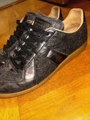 Maison Martin Margiela rare metallic & ull gats  - Väldigt rare Maison Martin Margiela  gats sneakers i ull och metallic material som är silver/svart. Använda fast fortfarande bra skick modellen är gjord att se lite använd ut.