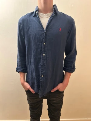 Blå linne skjorta från Ralph Lauren - Den har ett litet hål på framsidan bröst som ni kan höra av er för att se bilder på, annars superbra skick. Passar bra nu till våren och sommaren