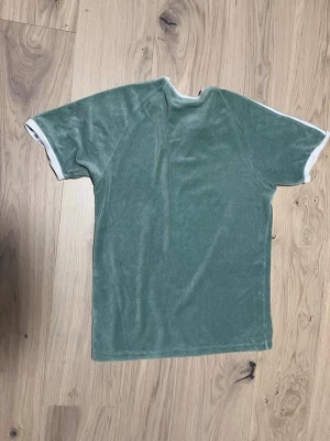 Grön t-shirt  från Adidas - Snygg grön t-shirt från Adidas i mjuk frotté. Inga hål eller problem med den nästan ny och använd få gånger