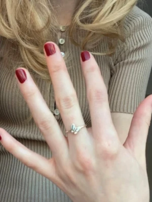 Söt silverring med fjärilsdetalj - En stilren och söt ring i silver med en liten fjärilsformad detalj framtill. Ringen har en tunn, enkel ringband. Perfekt accessoar för dig som vill ha en unik vintage stil på dina smycken. Helt i sterling silver