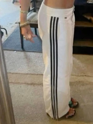 Vita Adidas mjukisbyxor med ränder - Vita adidas byxor med svarta ränder de Innerbenslängden är ca 74, första bilden är lånad ❣️