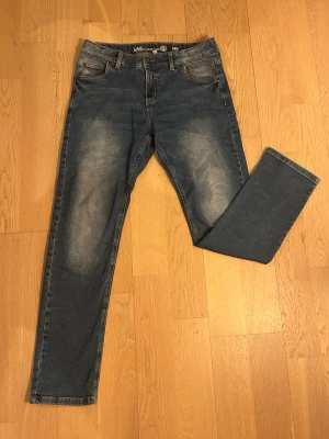 Blå raka jeans från L.A.B. - Riktigt feta vanliga raka jeans, perfekt för dig som vill se bra ut men ändå behålla dina pengar kvar. Jeansen har ett mindre hål men inget som syns direkt! Frågor? Kom in och ställ dom! Jeansen är hyperflex!