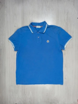 Moncler piké  - Blå monclear piké i storlek L/Xl Väldigt bra skick. Använd få gånger.