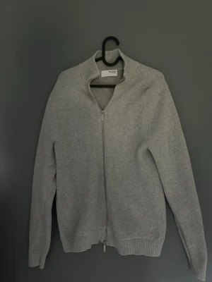 Grå stickad ziptröja ARKET - Snygg grå stickad ziptröja från selected homme med hög krage och hel dragkedja framtill. Passar riktigt bra inför våren och kan kombineras snyggt till olika stilar🔥 skicket är mycket bra. Storlek S. Hör av er för fler frågor😃