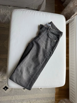 Grå raka jeans från Weekday - Snygga grå jeans från Weekday med klassisk femficksmodell och raka ben. Jeansen har en cool tvättad look och är perfekta för en avslappnad stil. Perfekt till sneakers eller boots.