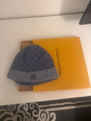 Navy Louis Vuitton mössa med rutmönster (sällsynt) - Säljer en snygg blå mössa från Louis Vuitton med klassiskt rutmönster och vikt kant. Mössan har en diskret LV-logga framtill och är tillverkad i mjukt material som känns lyxigt. Perfekt accessoar för dig som vill ha något exklusivt och stilrent. Denne riktigt sällsynt och unik, pris kan diskuteras!!!
