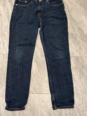Mörkblå raka jeans - Säljer ett par klassiska mörkblå jeans med rak passform och fem fickor. Jeansen har normal midja och subtila kontrastsömmar. Perfekta till en avslappnad stil och funkar året runt. Materialet är denim i bomull.