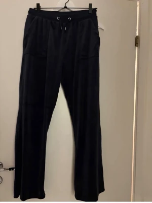 Juicy Couture byxor  - Svarta mjukisbyxor med raka ben och resår i midjan samt dragsko. Byxorna har två stora fickor fram och två bakfickor med knapp. Perfekta för en chill och avslappnad stil. Mjukt material som känns skönt mot huden. Uppsydda så de passar mig som är 168. 