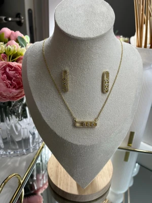 18k guldpläterat Messika set - Smyckesetet one ett halsband och örhängen i rostfritt stål, pläterat med 18k guld