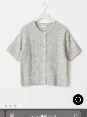 Grå kortärmad kofta Gina Tricot - Mysig gråmelerad kofta från Gina Tricot med korta ärmar och rund hals. Köpte för någon månad sen men endast använd någon enstaka gång💞köpt för 359 kr 
