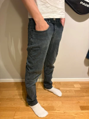 Giorgio Armani jeans👖gråa - Snygga gråa jeans med klassisk femficksdesign och dragkedjegylf. Jeansen har lite smalare passform och raka ben, perfekta till en avslappnad stil. Materialet är mjukt denim med lätt tvättad look och bälteshällor i midjan.🔥                     Storlek : 30 i midjan. 104 cm utsida och 77 insida ben.🦵 
