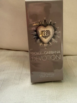Dolce & Gabbana Devotion Pour Homme - Dolce & Gabbana Devotion Pour Homme Eau de Parfum är en lyxig herrparfym i elegant silverfärgad förpackning med ett dekorativt hjärta och DG-logga. Doften har noter av citron, kaffe och patchouli. Tillverkad i Italien och passar dig som gillar exklusiva dofter. Säljes pga felköp skulle haft perfume varianten. Oöppnad 