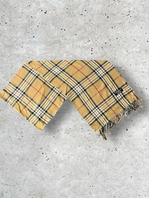Burberry halsduk - Säljer en snygg Burberry halsduk i den klassiska beige färgen med det välkända rutmönstret. Tillverkad i 100% mjuk och värmande ull.   📏 Mått: Längd-175, Bredd-33cm Pris kan diskuteras!