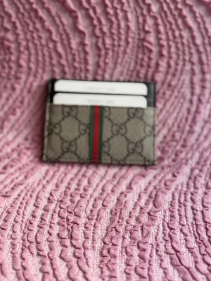  korthållare - Snygg korthållare  i beige och brunt  med klassisk grön och röd rand i mitten. Tillverkad i canvas med läderdetaljer. Perfekt för att hålla koll på dina kort med stil.kopia