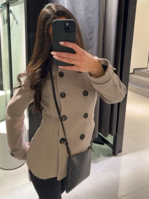 Beige kappa - Såå fin och elegant kappa med krage som inte finns att köpa mer! Passar perfekt nu till vår och till vilket tillfälle som helst! Jackan är lite figursydd och ger dig en superfin form! Är i jättefint skick men kommer tyvärr inte till någon större användning!🤎🤎