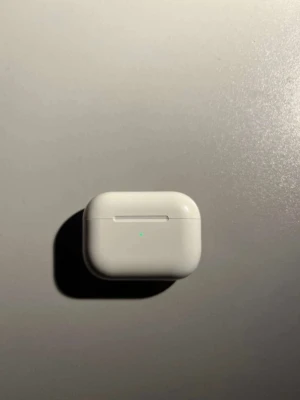 Apple AirPods Pro med laddningsetui - Snygga och smidiga Apple AirPods Pro i vitt med trådlös laddningsetui. Hörlurarna har en stilren, rundad design och är tillverkade i blank plast. Perfekta för musik, samtal och träning med aktiv brusreducering och enkel anslutning till iPhone.