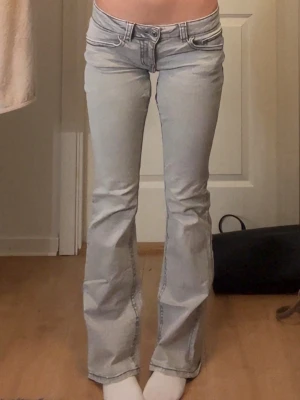 Två par bootcut jeans låg midja - Säljer två par jeans med bootcut-modell och låg midja. Ett par är gråa och det andra är svarta. Båda har klassisk femficksdesign och är tillverkade i mjukt denimtyg. Perfekta för dig som gillar en retro och avslappnad look. De är extra nersyda för hand och det ser ut som att dem grås syning håller på att gå upp lite om man känner att man själv fixar det så är det super men annars så skriv så ska jag se om jag kan fixa det men det beror på pris