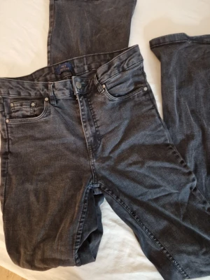 Mörkgrå jeans från NLY jeans - Snygga mörkgrå jeans från NLY jeans med klassisk femficksmodell och bootcut. Jeansen har normal midja och är tillverkade i mjukt bomullsdenim. Perfekta för en avslappnad och trendig look. Liten skada längst ner på baksidan av byxbenet(se bild) hund finns I hemmet.